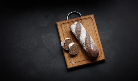 Premium Photo Sliced Rye Flour Baguette Lies On A Brown Wooden Board