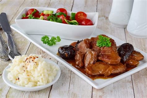 A Carne Da Vitela Cozinhou Ameixas Secas Fumado Em Uma Placa Branca