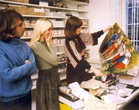 Three Women Looking At Art Work On A Table