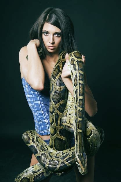 Premium Photo Sexy Brunette Holding Python Over Black