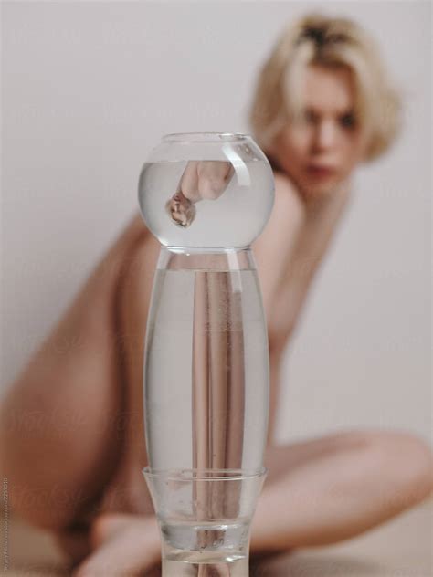 Nude Woman Reflecting Through Glass Of Water By Stocksy Contributor