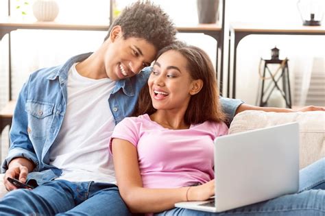 Premium Photo Positive Black Teen Couple Relaxes On A Couch Together