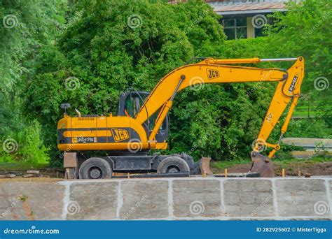 An Excavator In Front Of A Pile Of Rubble During An Urban Redevelopment