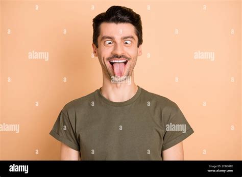 Photo Of Foolish Guy Crossing Eyes Stick Out Tongue Wear Green T Shirt