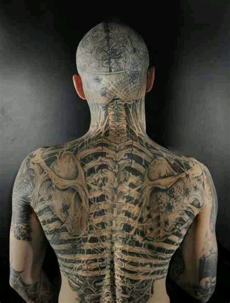 The Back Of A Man S Body With Tattoos On His Upper And Lower Torso