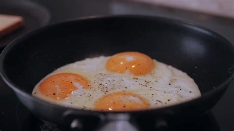 Frying Eggs In A Frying Pan 13277861 Stock Video At Vecteezy