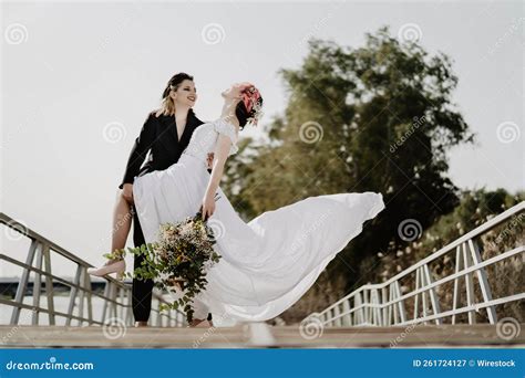 Closeup Of A Lesbian Female In Black Holding Brides Feet Up On The Bridge Stock Image Image Of