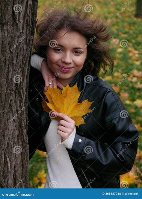 Vertical Of A Curly Brunette Caucasian Female Posing With A Yellow