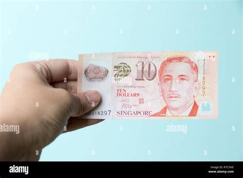 Business Man Hold Singapore Dollar Bank Note On Blue Concrete