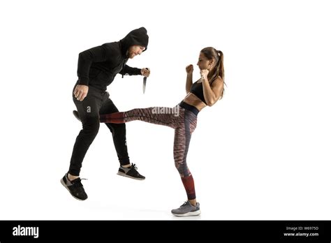 Man In Black Outfit And Athletic Caucasian Woman Fighting On White