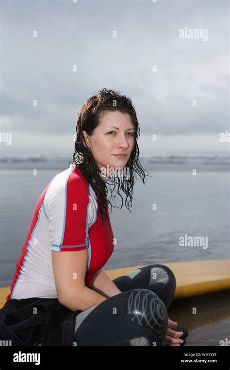 Side View Of Thoughtful Young Woman With Surfboard Looking Away While