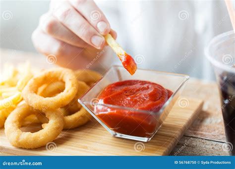 Close Up Of Hand Dipping French Fries Into Ketchup Stock Photo Image