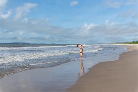 Una Mujer Adulta En Bikini Caminando Bajo La Fuerte Luz Del Sol En La Playa Foto Premium