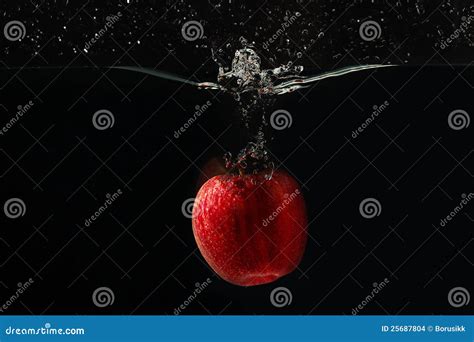 Red Apple Falling Into The Water With A Splash Royalty Free Stock Image