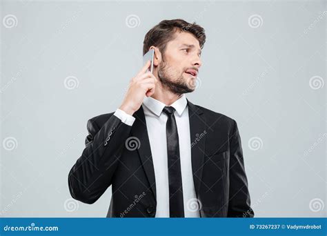 Handsome Young Businessman Talking On Mobile Phone And Looking Back