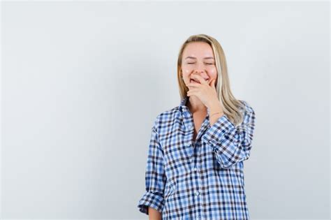 Dame Blonde En Chemise Décontractée Tenant La Main Sur La Bouche Et à La Joyeuse Photo Gratuite