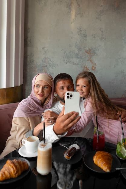 Familia tomando selfie juntos mientras están en un restaurante Foto