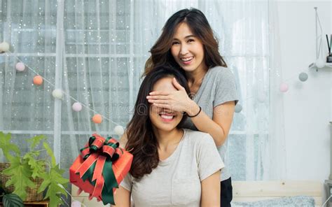 Asian Woman Surprise Her Girlfriend By Giving A Gift In Bedroom LGBT Lesbian And Love Concept