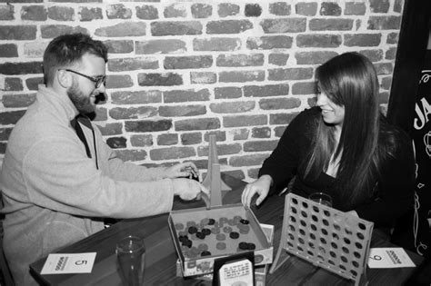 Two People Sitting At A Table Playing Board Games