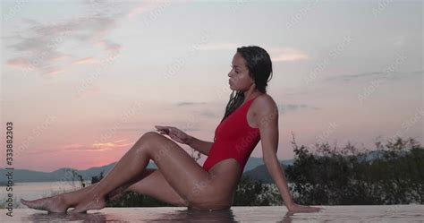 Beautiful Brunette Woman In Red Swimsuit Posing By Outdoor Pool Over