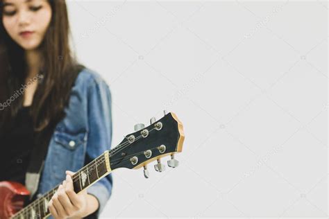 Primer plano de la joven guitarrista tocando la guitarra eléctrica