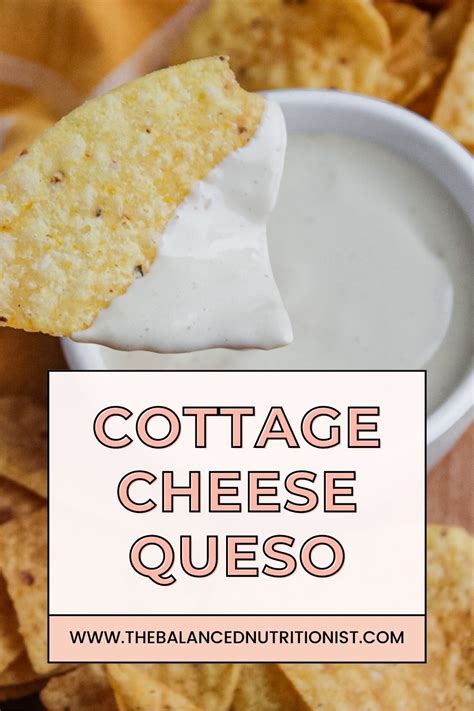 A Close Up Shot Of A Tortilla Chip Dipped In Cottage Cheese Queso With