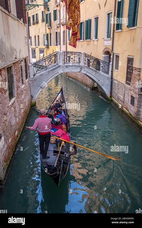 Tourists Riding In A Traditional Gondola On A Venetian Canal Stock