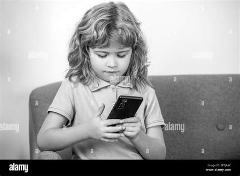 Little Boy Using Smartphone Looking At Screen Child Holding Phone In