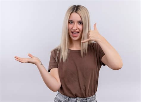 Joyeuse Jeune Fille Blonde En Appareil Dentaire Faisant Le Geste D Appel Et Montrant La Main