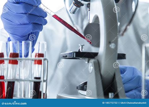 Lab Technician Analyzing A Blood Sample In Test Tube At Laboratory With