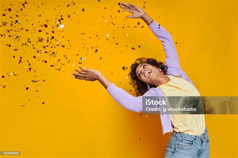 Happy African Woman Throwing Confetti And Smiling While Standing