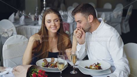 Happy Loving Couple Is Holding Hands Talking And Kissing During