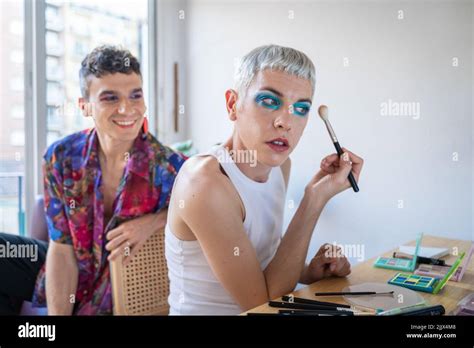 Caucasian Gay Man Looking At Boyfriend Applying Makeup In Front Of