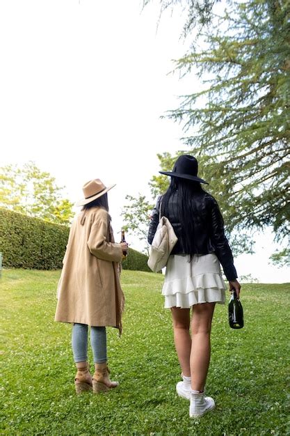 Vista posterior de dos chicas jóvenes que llegan al parque con una