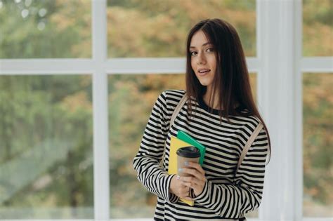 Retrato De Una Estudiante Sonriente Con Cuadernos Y Una Mochila El