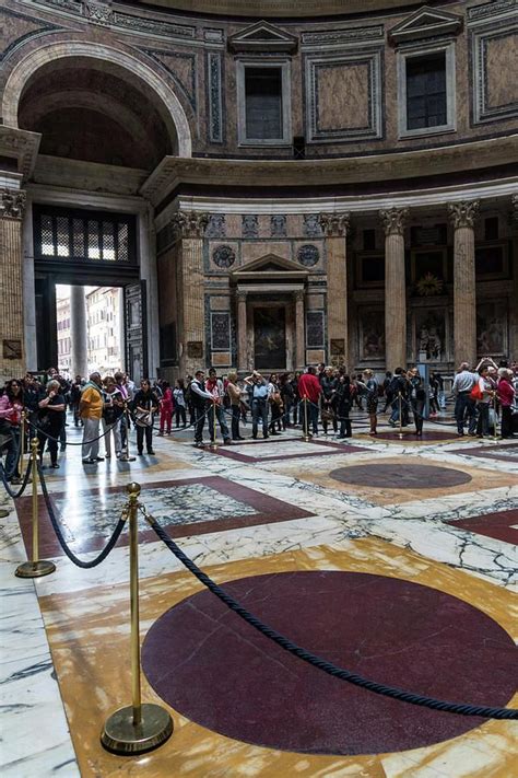 A Group Of People Standing In A Large Room With Marble Flooring And