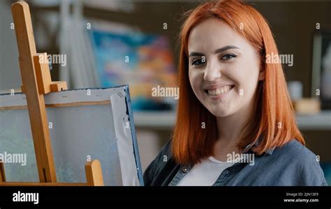 Caucasian Woman Artist Girl Painter With Red Hair Enjoying Art Work With Paints Creates Picture