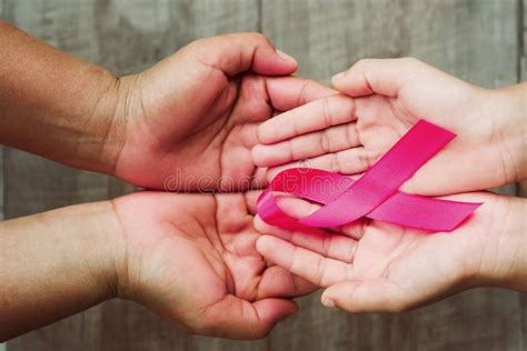 Concept Healthcare And Medicine Hand Holding Pink Ribbon On Wood