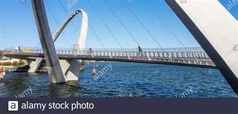 Cyclists Riding Their Bikes Over The Elizabeth Quay Bridge A Pedestrian