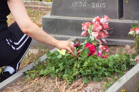 Mujer Pone Flores En La Tumba Foto Premium