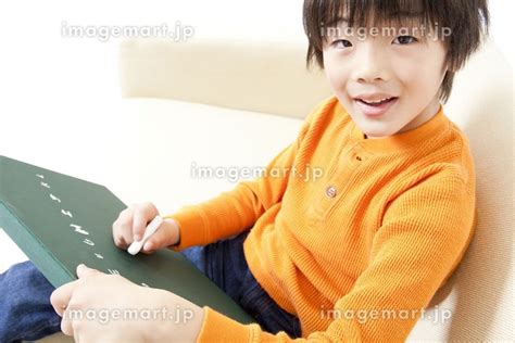 黒板に文字を書く男の子の写真素材 [23999763] イメージマート