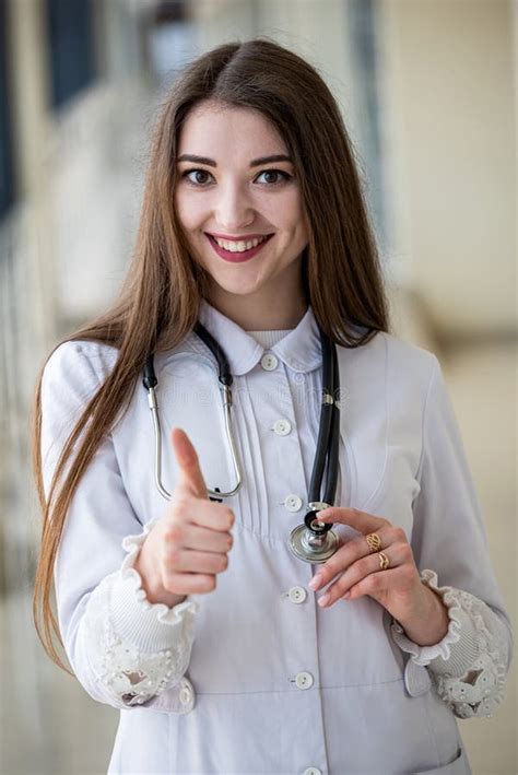 Smiling Female Doctor With Cute Friendly Appearance In Scrubs