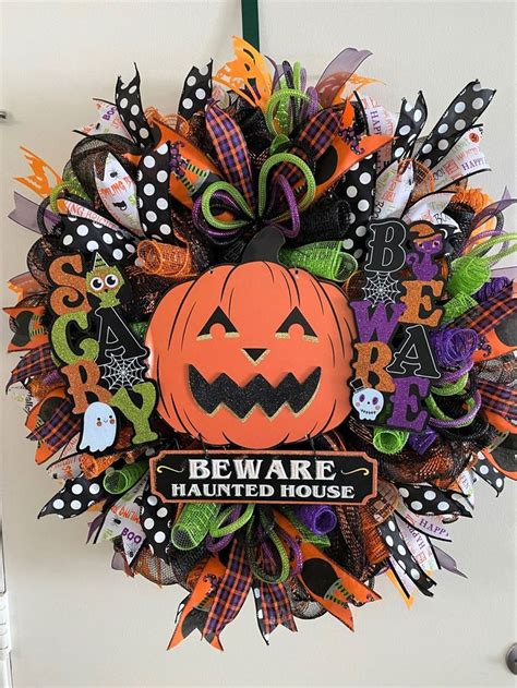 A Wreath Decorated With Halloween Decorations On The Front Door