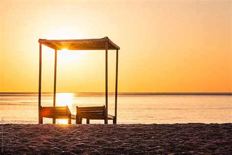 "Wooden Lounge Chairs And Canopy On The Beach" by Stocksy Contributor "Helen Sotiriadis" - Stocksy