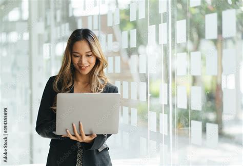 Cheerful young woman holding laptop computer. Pretty lady model with ...