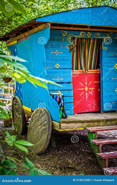 Blue And Brightly Painted Wooden Gypsy Caravan Parked In Woods Stock