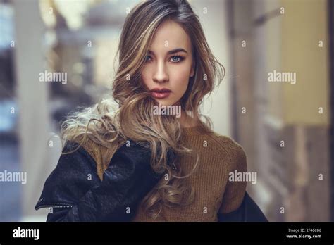 Femme blonde en contexte urbain Belle jeune fille vêtu de noir et jupe ensemble debout dans la