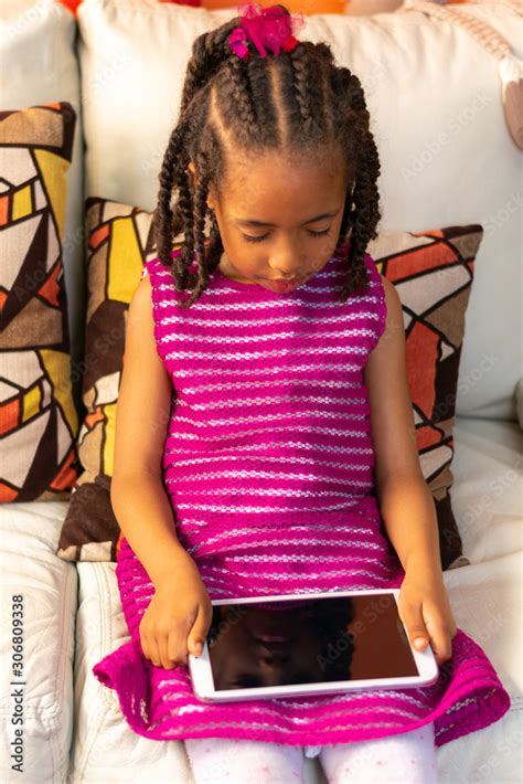 Five Year Old Colombian Afro Descendant Latina Girl Sitting On The Sofa Next To The Christmas