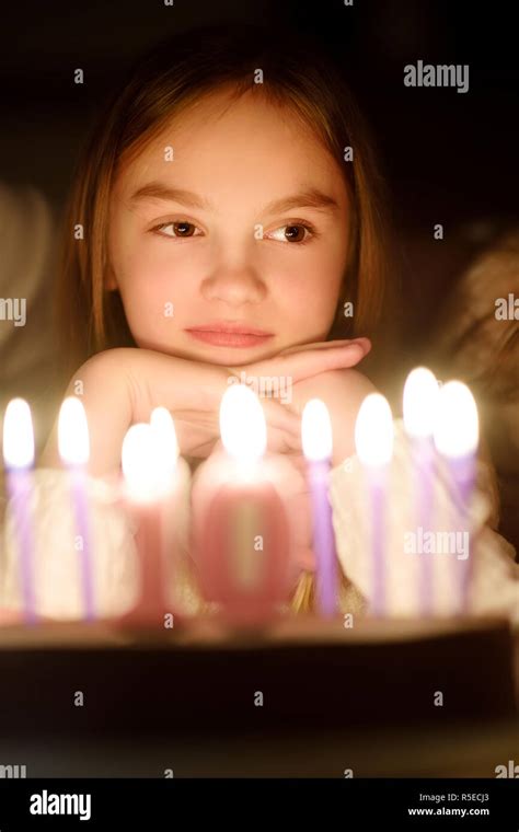 Cute ten years old girl making a wish before blowing candles on her ...