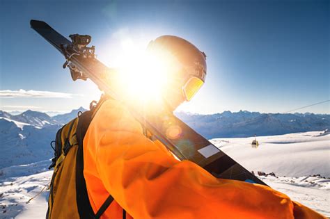 The Skier Stands On The Top Of The Mountain And Enjoys The View Of The
